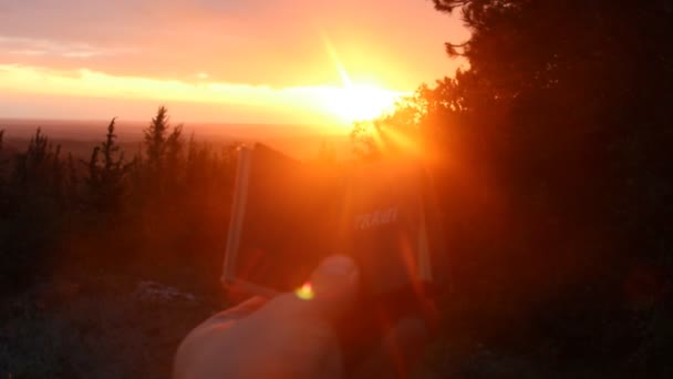 Reizen idee - reiziger een boek met de tekst bedrijf op de zonsondergang — Stockvideo