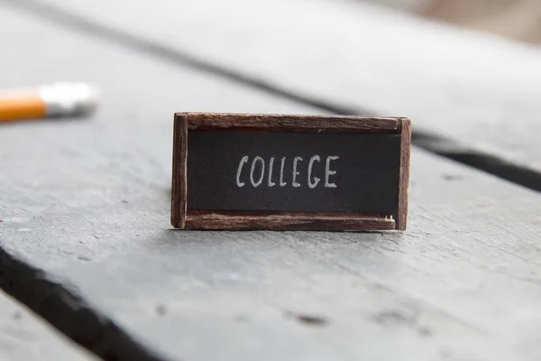 College-Idee, Etikett auf einem alten Vintage-Tisch — Stockfoto