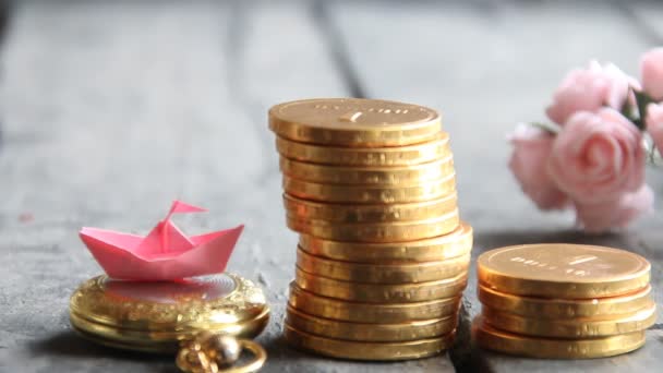 Starta upp affärsidé. Travar av gyllene mynt och ett papper båt. — Stockvideo