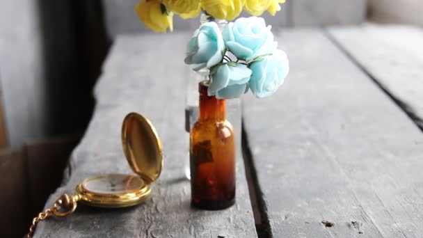 Flowers in bottles on vintage table. — Stock Video