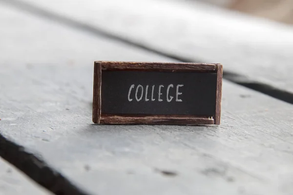 Concepto de la universidad, etiqueta en una mesa vieja — Foto de Stock