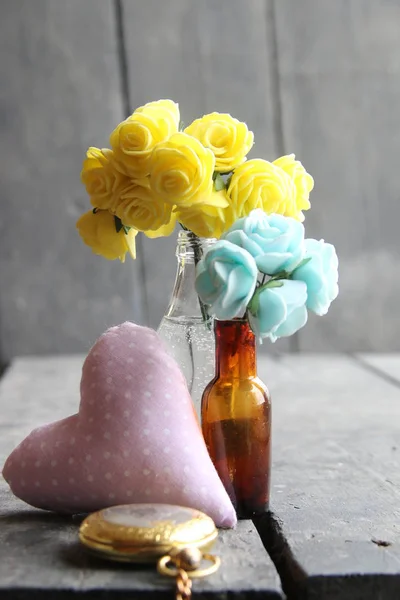 Flores em garrafas na mesa vintage de madeira . — Fotografia de Stock