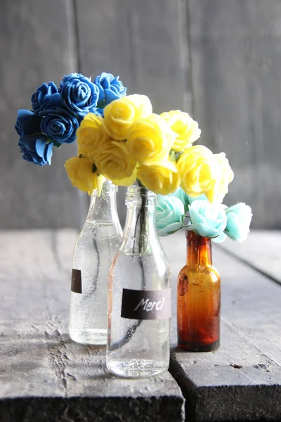 Merci-Etikett und schöne Blumen in den Flaschen — Stockfoto