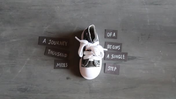 Journey of thousand miles begins with single step, tags with quote and sneakers — Stock Video