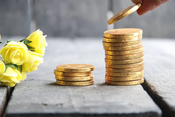altın sikke ve güzel çiçekler tutan el