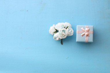 Gül ve mavi bir arka plan üzerinde hediye kutusu