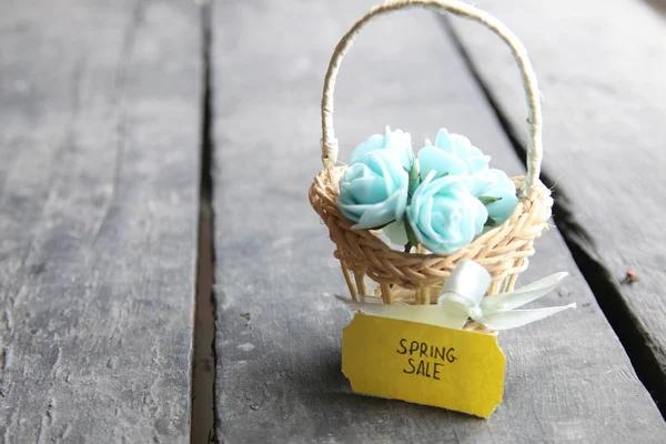 spring sale tag and flowers in a small basket