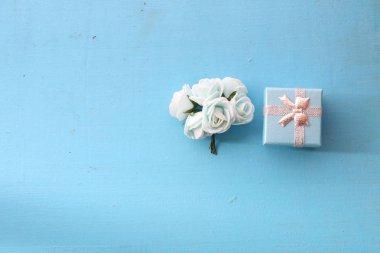 Gül ve mavi bir arka plan üzerinde hediye kutusu