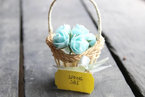Etiqueta de venda de primavera e flores em uma pequena cesta em um fundo vintage — Fotografia de Stock