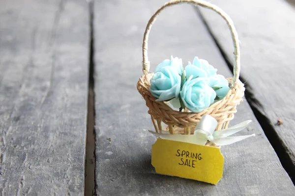 Etiqueta de venda de primavera e flores em uma pequena cesta em um fundo vintage — Fotografia de Stock