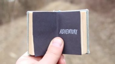 Macera. Gezgin bir kitapla metin tutar