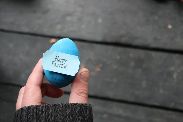 Wesołych Świąt. Ręka trzyma jajo z tagu. Miejsce. — Zdjęcie stockowe