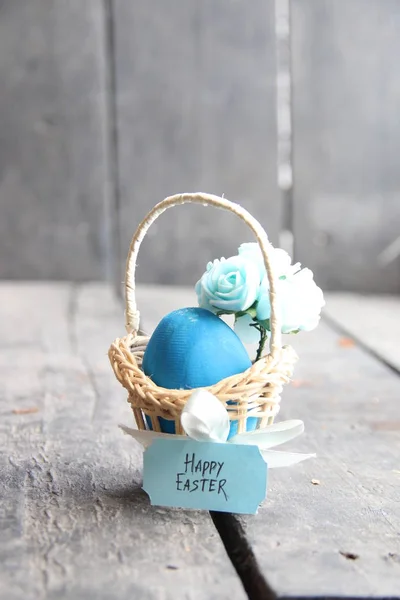 Frohe Ostern. Osterei im Korb auf Vintage-Hintergrund und Frühlingsblumen. — Stockfoto
