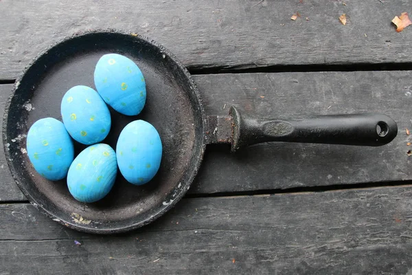 Velikonoční vejce v pánvi na vinobraní dřevěné pozadí — Stock fotografie