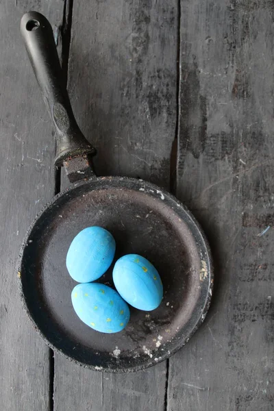 Пасхальные яйца в сковороде на деревенском деревянном фоне — стоковое фото