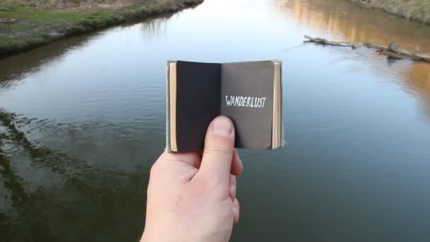 Idea wanderlust, viajero sostiene un libro con texto — Vídeo de stock