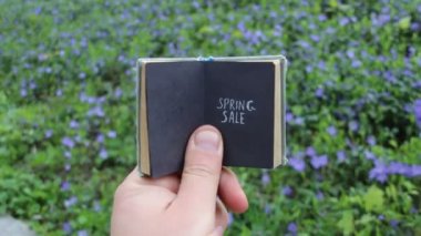 Bahar satış konsepti, mavi çiçekli metin ve bahar alan kitapla