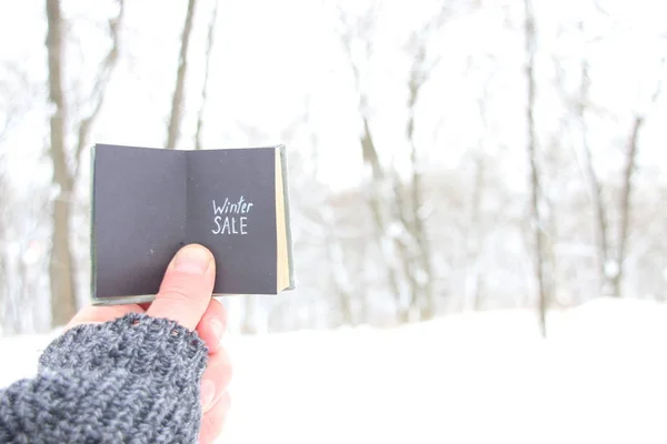 Vinter försäljning man håller en bok med inskriptionen — Stockfoto