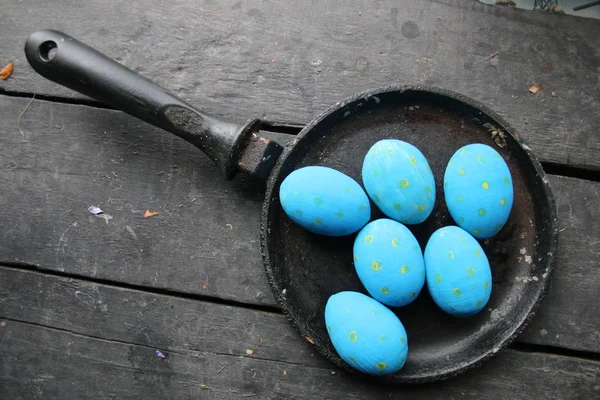 Пасхальные яйца в сковороде на винтажном столе — стоковое фото