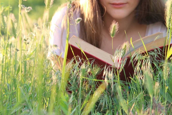 Jovem mulher relaxante e livro de leitura — Fotografia de Stock