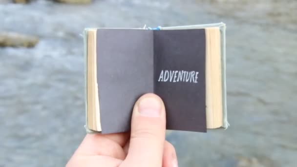 Aventura. El viajero sostiene un libro con texto — Vídeos de Stock