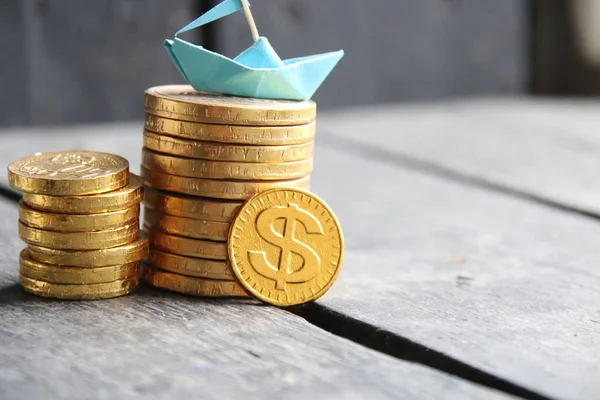 Graf zlatých mincí a papírového člunu — Stock fotografie