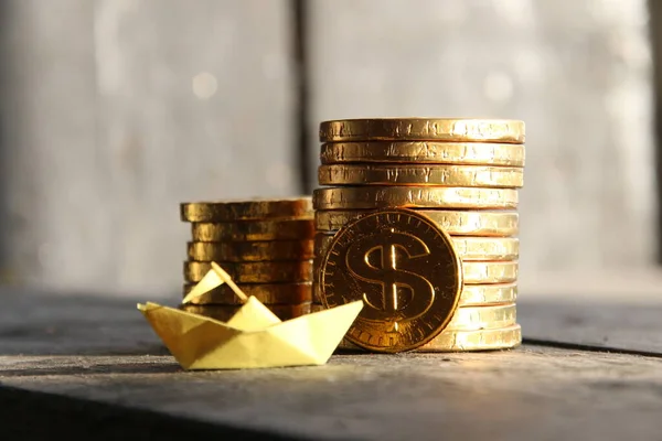 Startup concept, grafiek van gouden munten en een papieren boot — Stockfoto