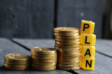 İş planı konsepti. Kelime planı ve yığınla altın para..