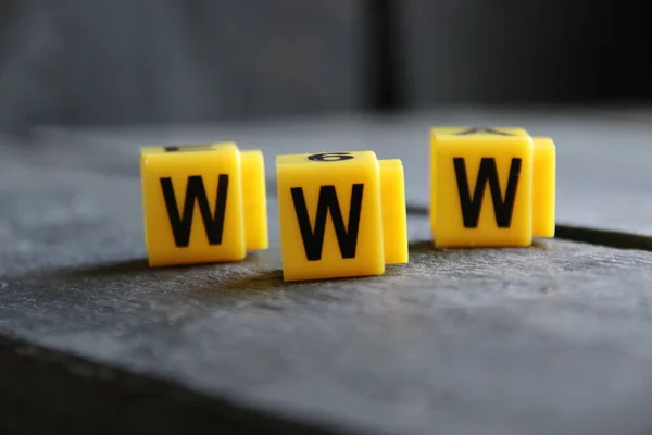 Web a www koncept. Žluté písmena na vinobraní pozadí. — Stock fotografie