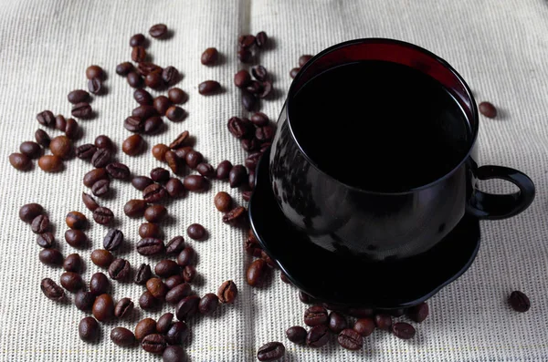 Σκούρα Κούπα Καφέ Φόντο Λινάτσα Διάσπαρτους Κόκκους Καφέ Στο Κοντινό — Φωτογραφία Αρχείου