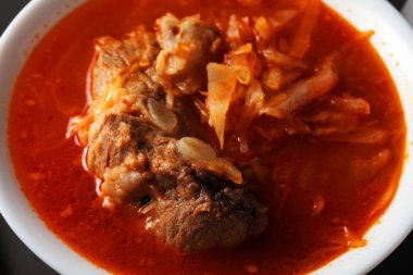 borsch in a white plate on a dark table
