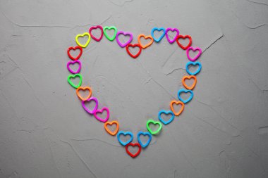 Kalp, beton bir arka planda dokumak için renkli lastik bantlarla dolu.