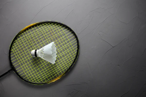 badminton racket and shuttlecock on concrete background with place for your text