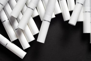 Esmer arka planda beyaz filtreli sigaralar.