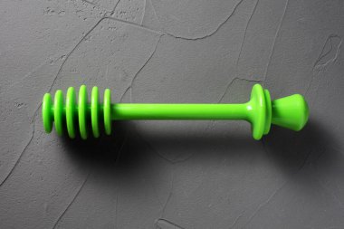 Beton arka planda bal için plastik yeşil kaşık