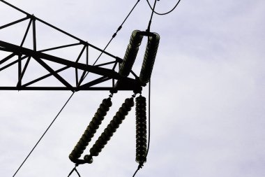 Yüksek voltajlı elektrik kablolarından oluşan bir direkte yalıtkan.