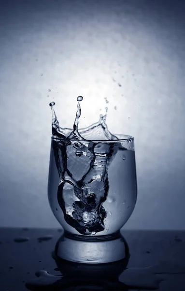 Spritzer Aus Einem Glas Beim Würfeln Von Eiswürfeln Vignettierung — Stockfoto