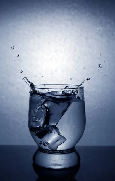 Spritzer Aus Einem Glas Beim Würfeln Von Eiswürfeln Vignettierung — Stockfoto