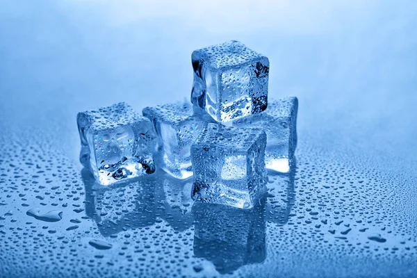 Artificial ice cubes with water drops. Tinted in blue.