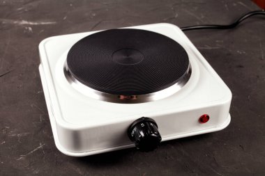 single-electric stove on a dark kitchen table, selective focus clipart