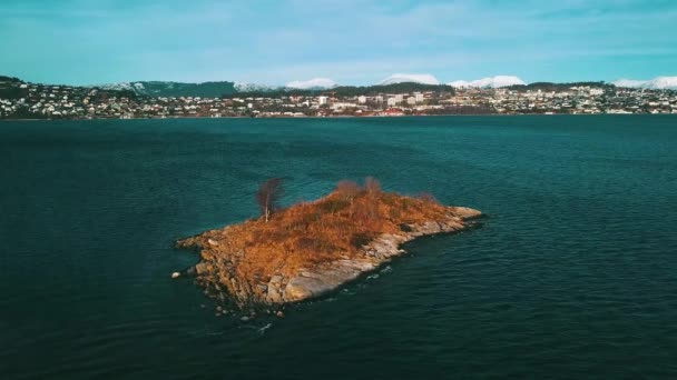 小さな岩の多い島へのゆっくりとした飛行は海に横たわっている 街の裏側だ 光の風 冬の終わり — ストック動画
