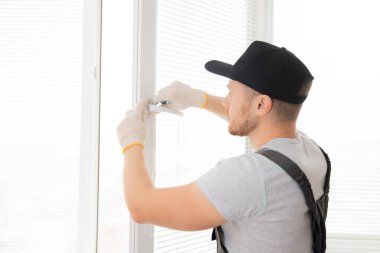 İnşaat işçisi eve plastik beyaz upvc pencereler takıyor