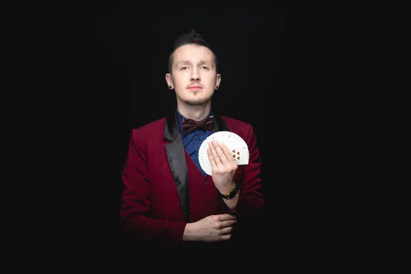Illuzionista ember mutatja rajongó kártyázás a kezében a fekete háttér — Stock Fotó