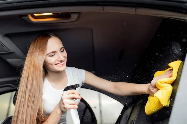 Mytí aut, dívka pracovník čištění sprej eko interiér moderní mikrovlákno a konzole auto — Stock fotografie