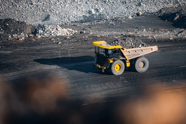 Big yellow mining truck for anthracite. Open pit mine, extractive industry for coal