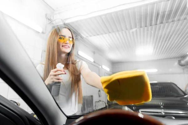 Piękne kobiety pracownik mycie przedniej szyby z gąbką na samochodzie, okno czyste spray — Zdjęcie stockowe