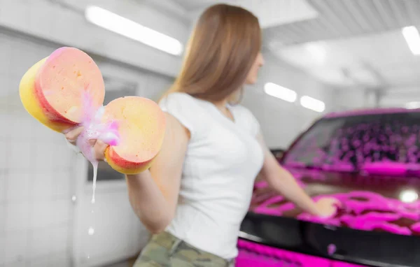 Dívka vymačkává houbu z pěny po mytí auta — Stock fotografie