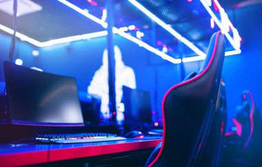Bulanık arka plan bilgisayar bilgisayarı, klavye koltuğu, mavi ve kırmızı ışıklar. Oyuncular için çevrimiçi esports arenasını kavramsallaştır