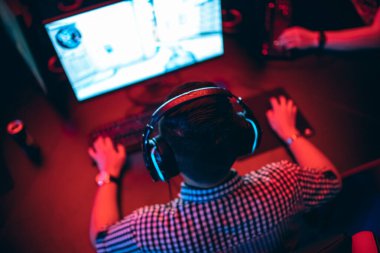 Bulanık arka plan profesyonel oyuncu turnuva oynuyor çevrimiçi oyun bilgisayarı kulaklıklı, kırmızı ve mavi