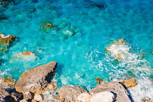 Blå smaragd havsvatten med stora stenar stranden. Klippig strand transparent turkos botten Malta — Stockfoto